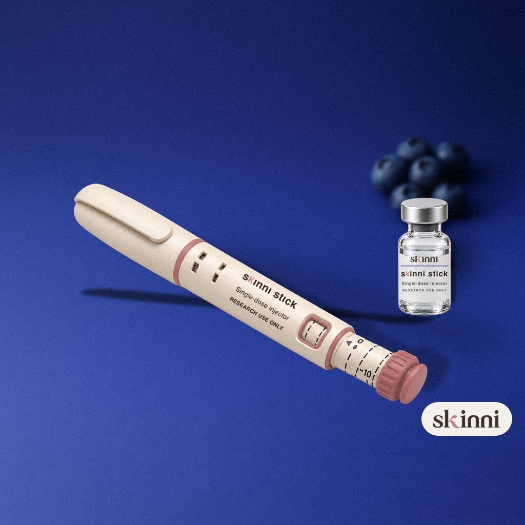 A clear DSIP research vial on a coloured plaster ledge, with botanicals beside it