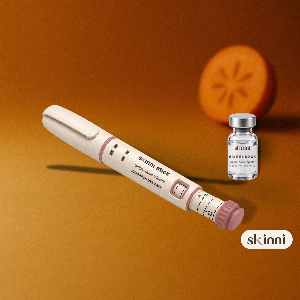 A clear Ipamorelin research vial on a coloured plaster ledge, with botanicals beside it