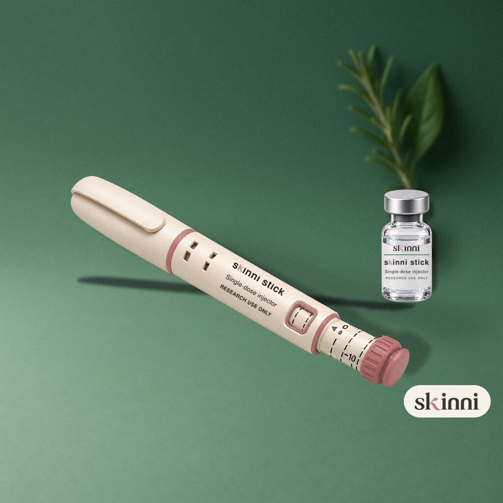 A clear KPV research vial on a coloured plaster ledge, with botanicals beside it