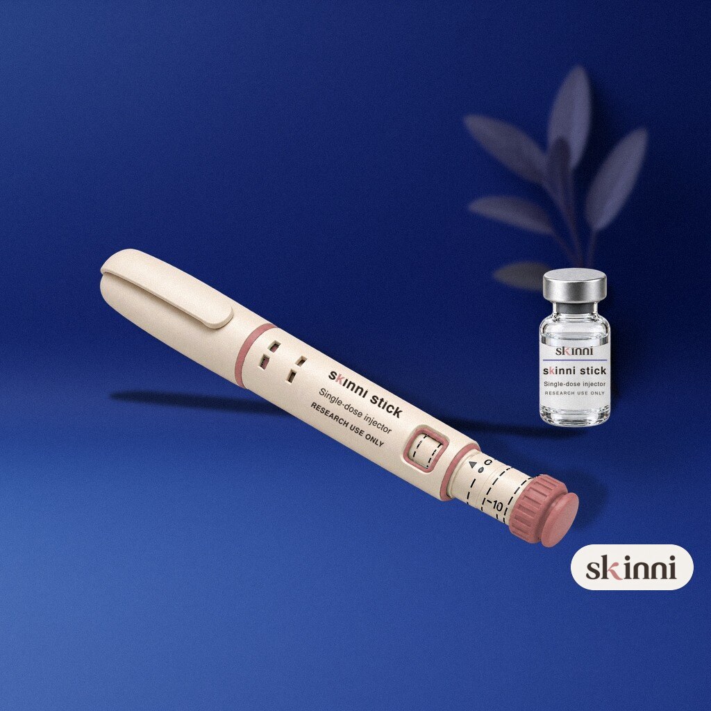 A clear Selank research vial on a coloured plaster ledge, with botanicals beside it