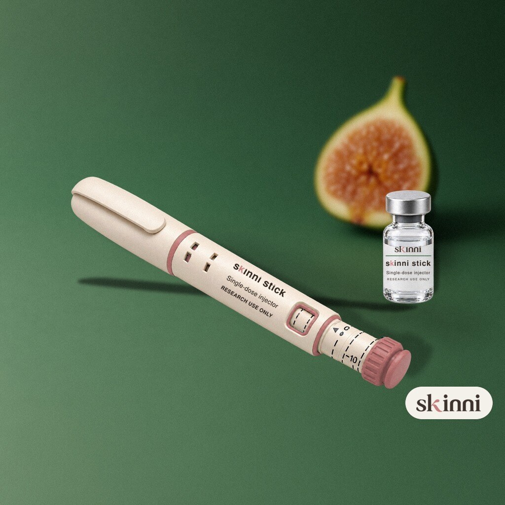 A clear TB-500 research vial on a coloured plaster ledge, with botanicals beside it